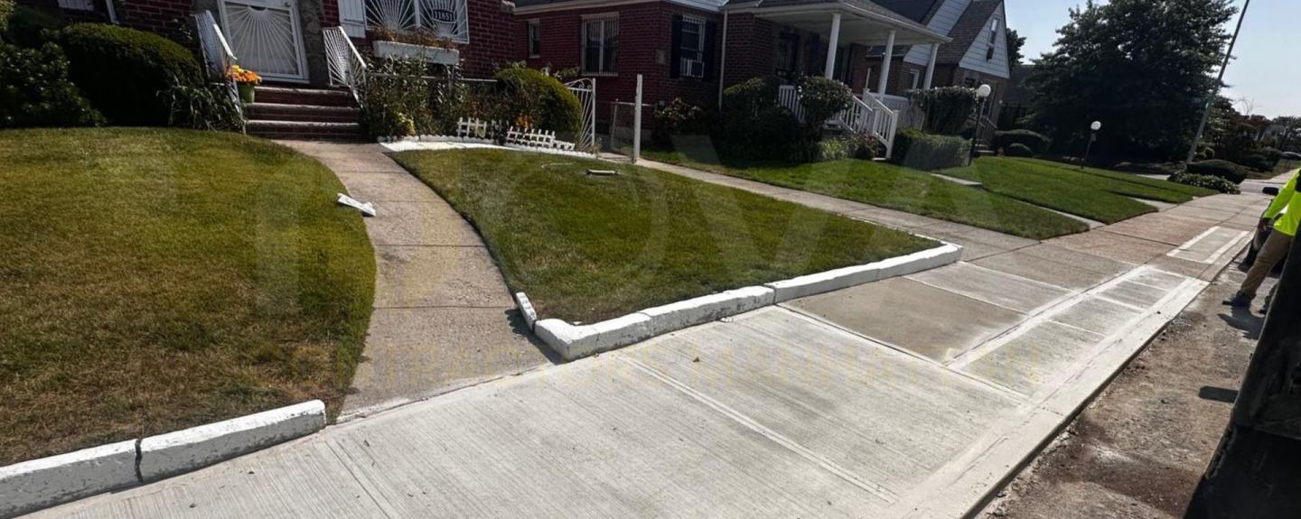 Newly poured concrete sidewalk and curb in front of residential homes