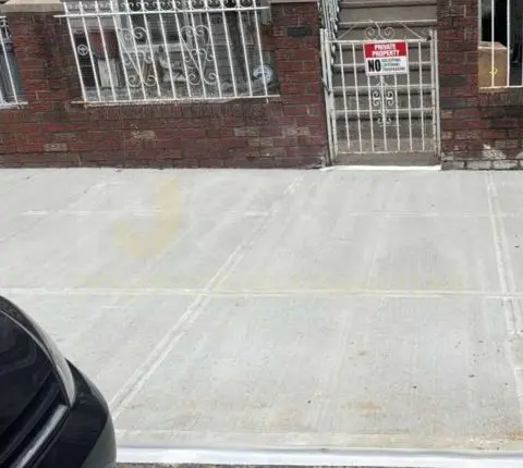 Replaced concrete sidewalk flags in front of a brick row house